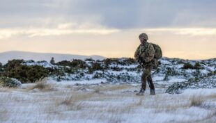 Soldier walking across snowy landscape